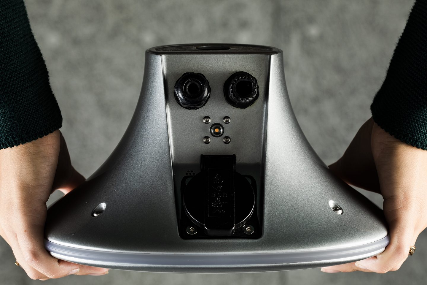 Woman holds a charging station from Charge Amps, Charge Amps Halo