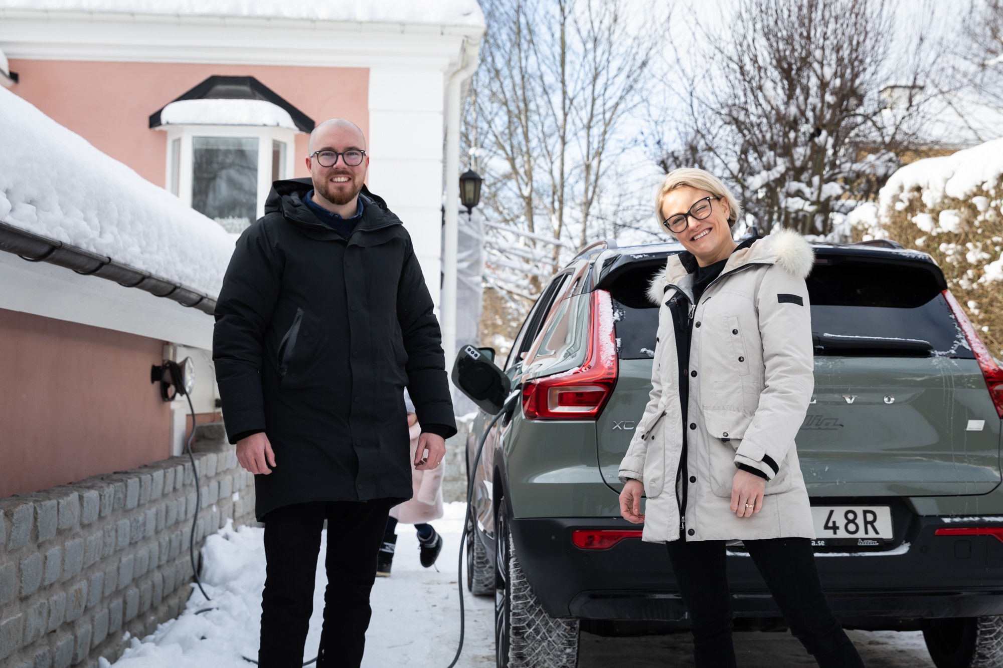 Man and a woman infront of their electric car